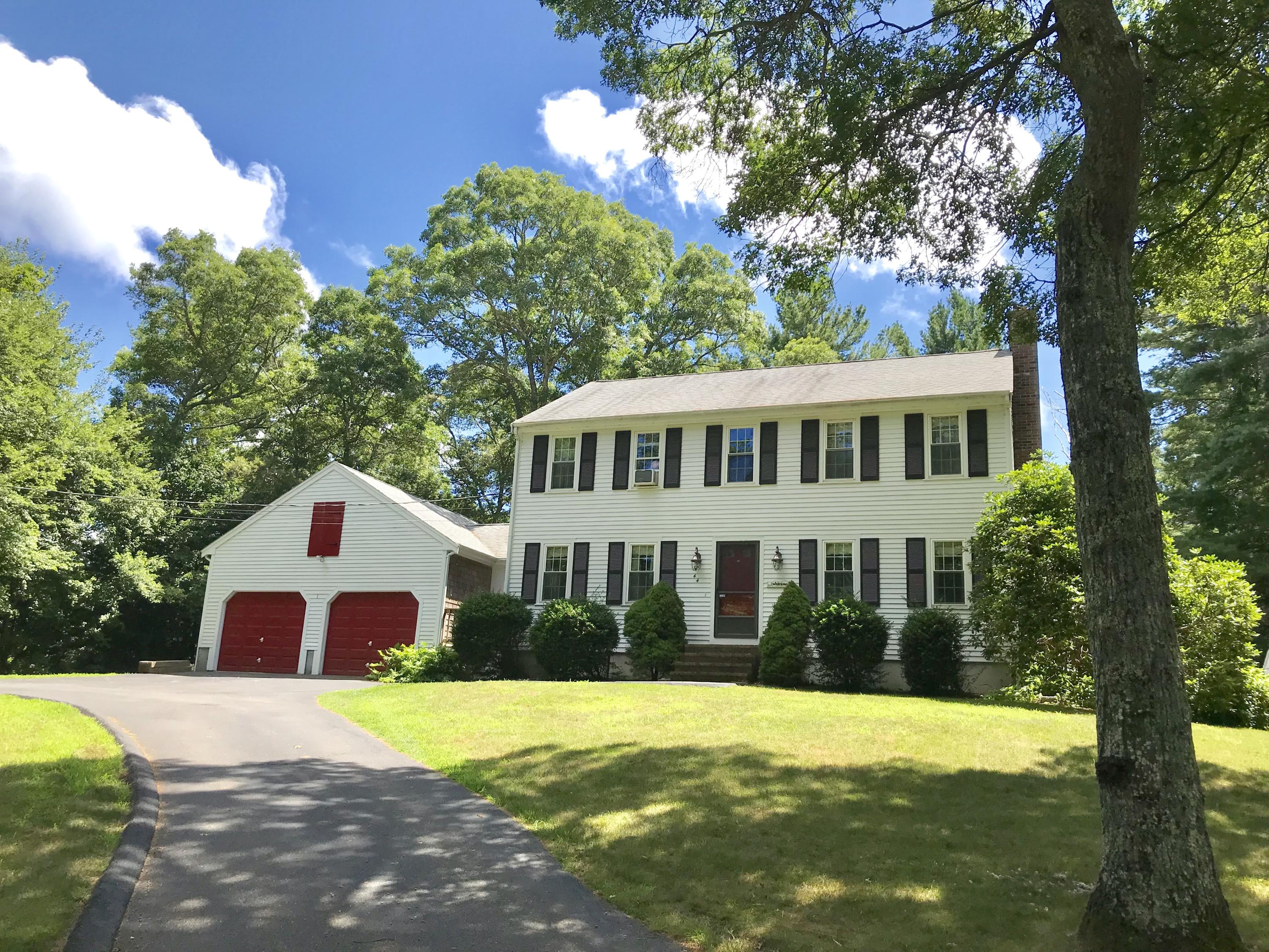 a view of a house with a yard and large tree