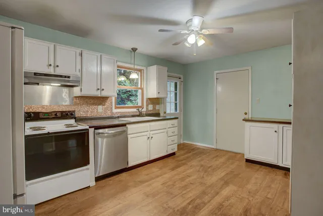 a kitchen with a stove a sink and a refrigerator