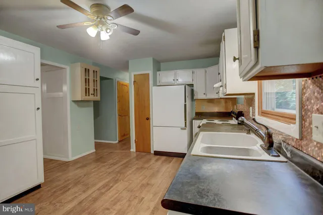 a view of a kitchen with a sink and refrigerator