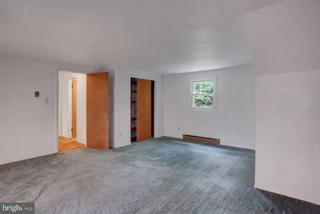 an empty room with windows and closet