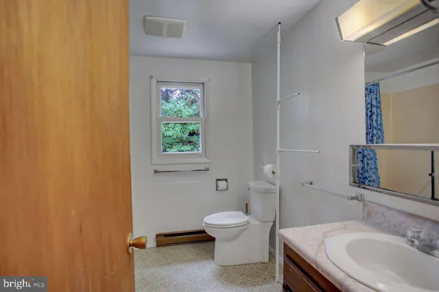 a bathroom with a granite countertop toilet a sink and a mirror