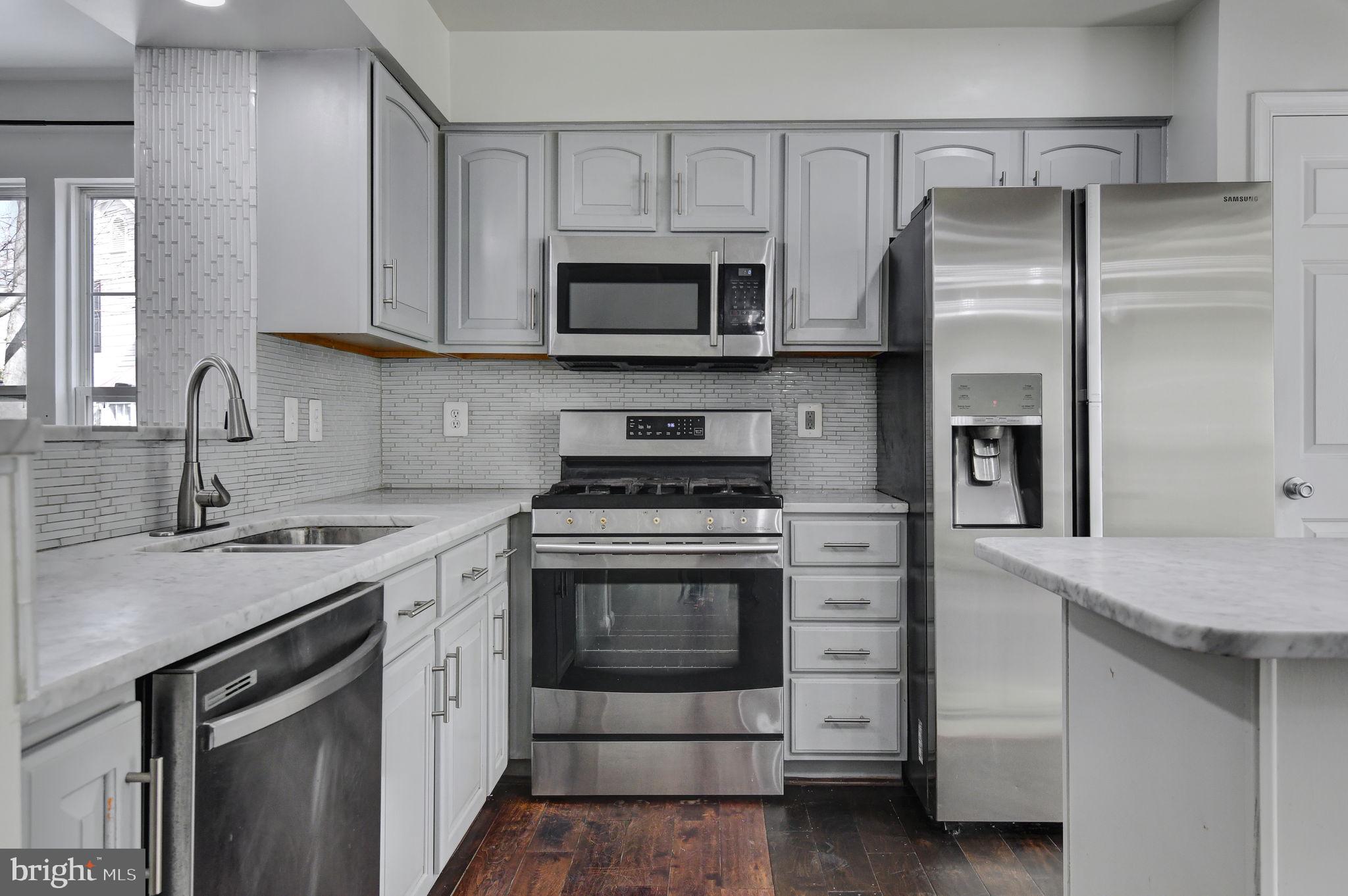 4013 Mammoth Cave Loop Dumfries, VA 22025 - Photo 12 of 38 a kitchen with white cabinets stainless steel appliances and sink