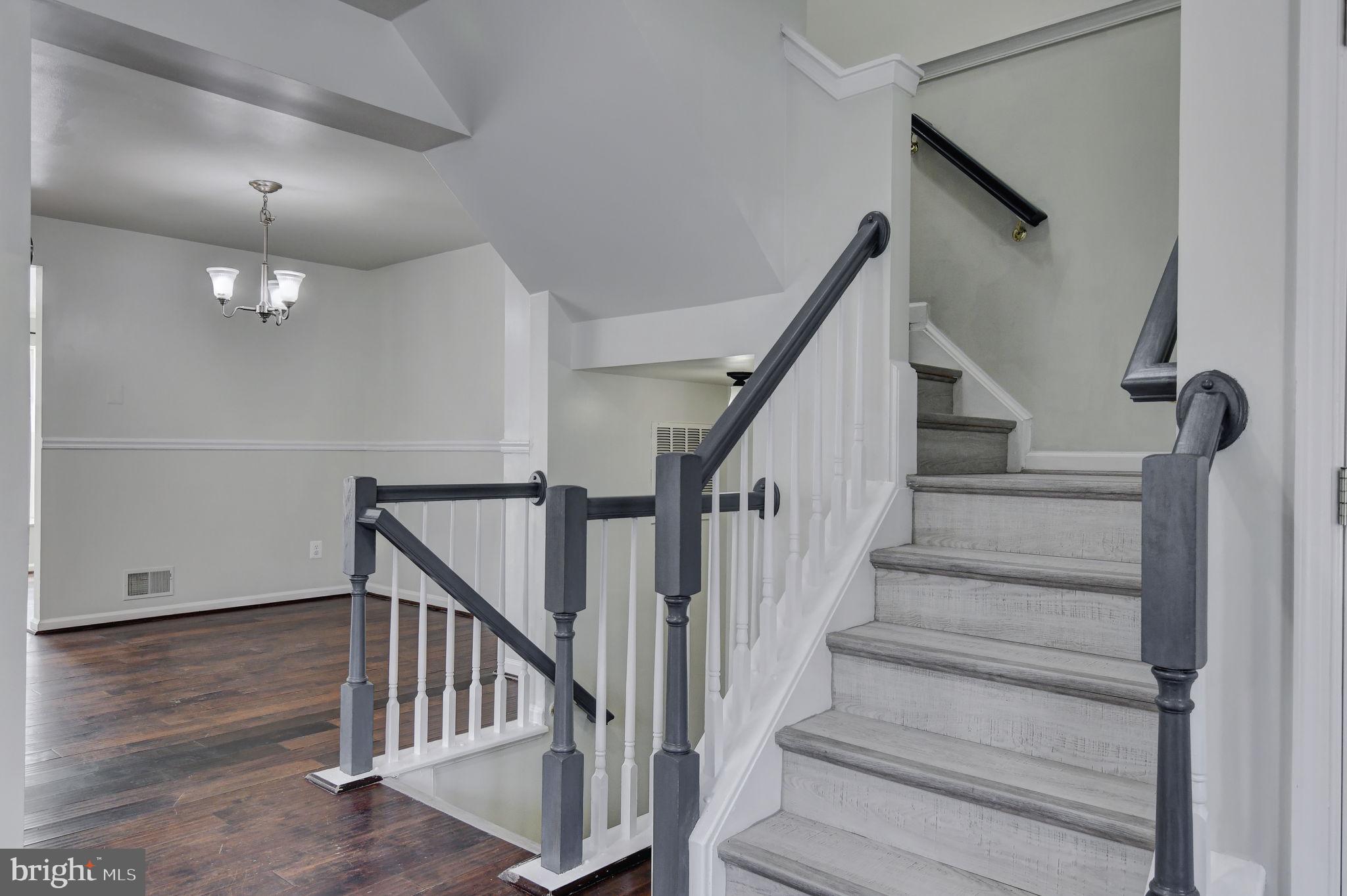 4013 Mammoth Cave Loop Dumfries, VA 22025 - Photo 8 of 38 a view of staircase with lots of frames on wall and wooden floor