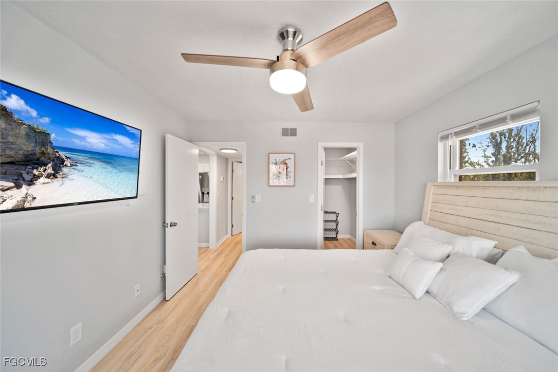 16881 Davis Road, Unit 721 Fort Myers, FL 33908 - Photo 18 of 23 a bedroom with a large bed and a chandelier