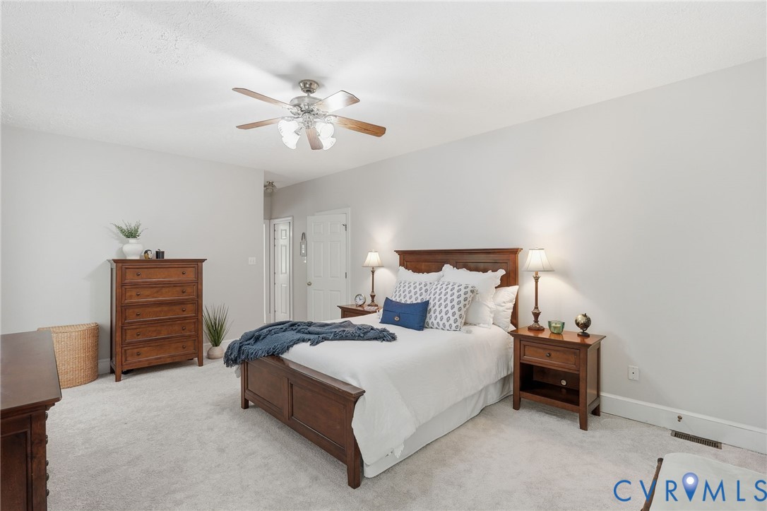 12123 Deer Ridge Court Ashland, VA 23005 - Photo 37 of 63 a bedroom with a bed and a chandelier