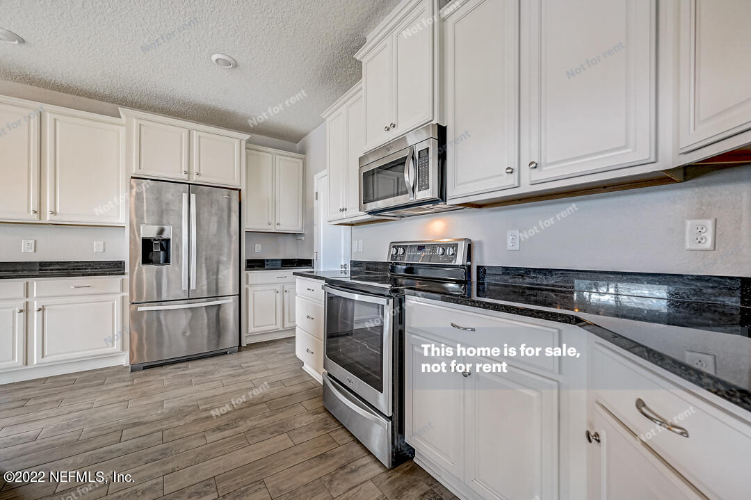 68 Redland Way Jacksonville, FL 32218 - Photo 14 of 36 a kitchen with stainless steel appliances granite countertop a refrigerator and a stove top oven