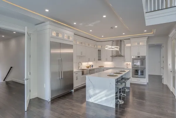 a kitchen with stainless steel appliances kitchen island granite countertop a refrigerator and a stove top oven