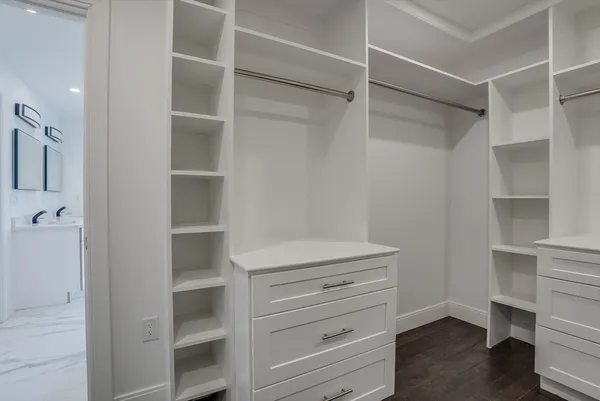 a view of walk in closet with empty racks