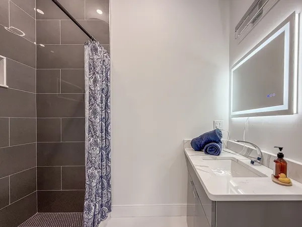 a bathroom with a sink a window and shower
