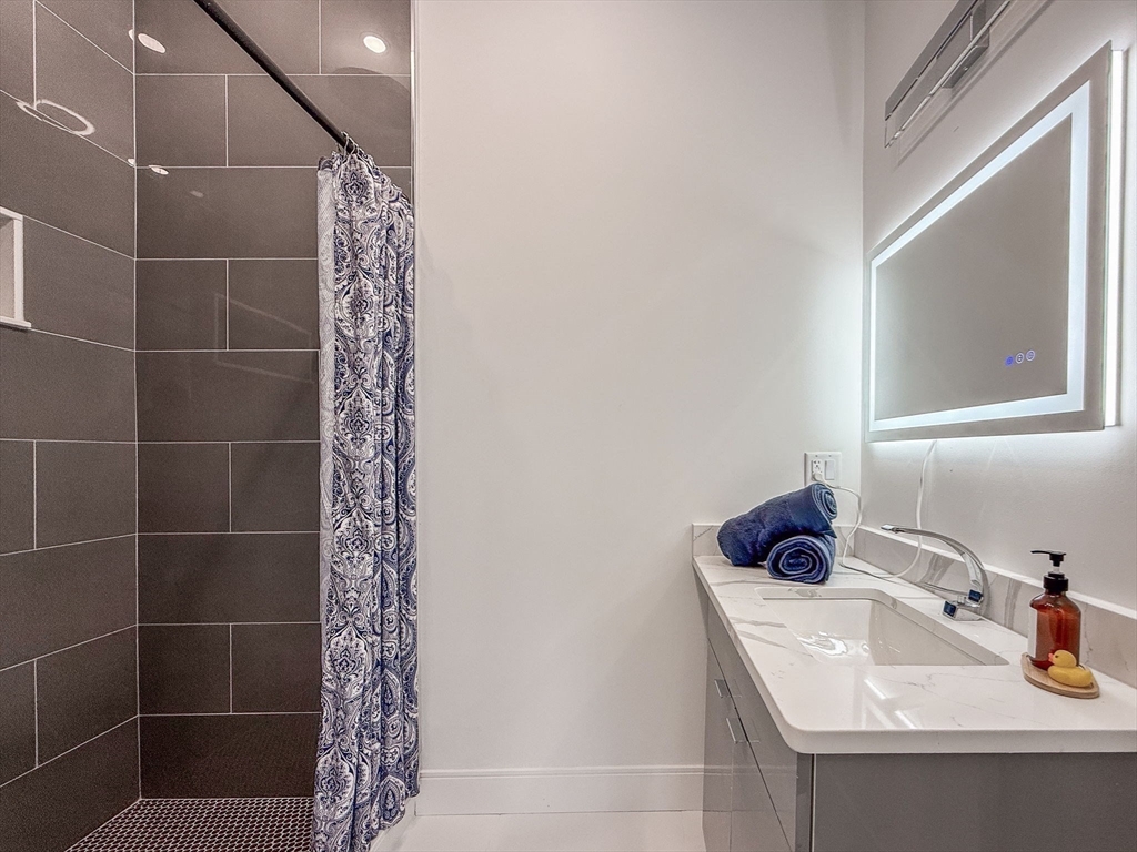 709 Main Street Acton, MA 01720 - Photo 10 of 42 a bathroom with a sink a window and shower