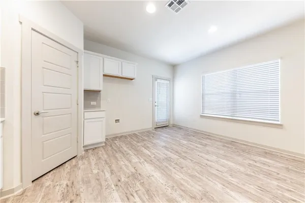 an empty room with a window and a ceiling fan
