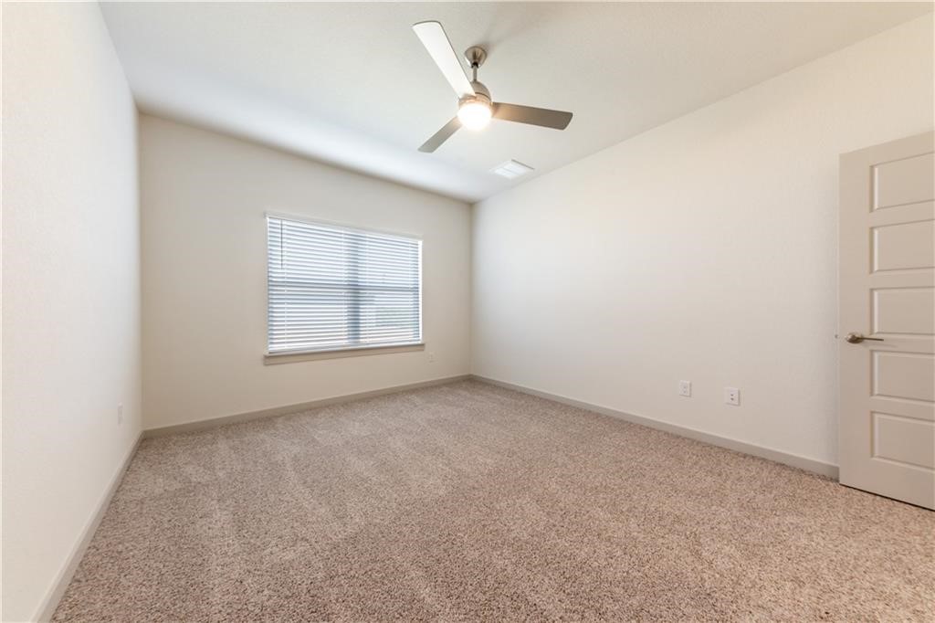 8304 Mimi Lane Austin, TX 78724 - Photo 14 of 32 an empty room with a window and a ceiling fan