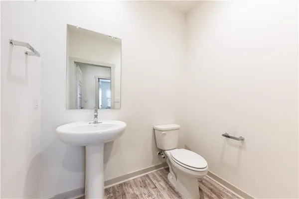 a bathroom with a sink a toilet a mirror and shower