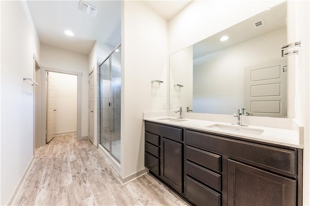 8304 Mimi Lane Austin, TX 78724 - Photo 17 of 32 a spacious bathroom with a double vanity sink and mirror