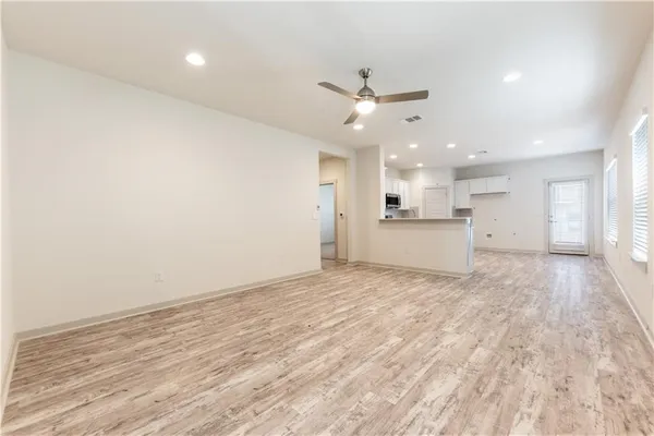 a kitchen with a sink dishwasher and white cabinets with wooden floor