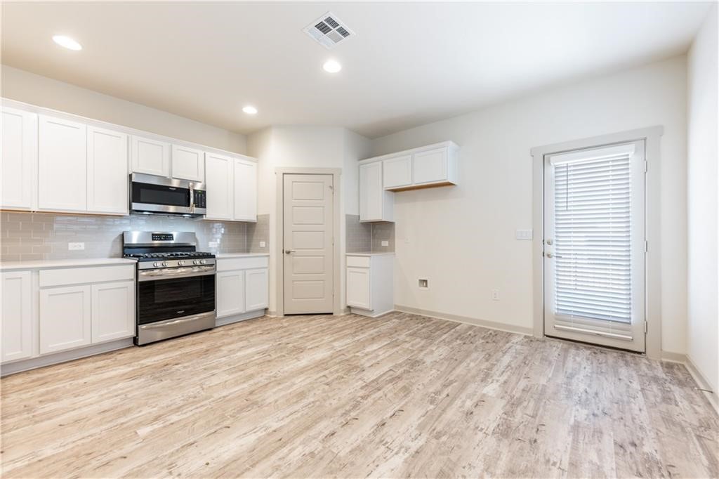 8304 Mimi Lane Austin, TX 78724 - Photo 6 of 32 a kitchen with granite countertop a stove top oven and cabinets