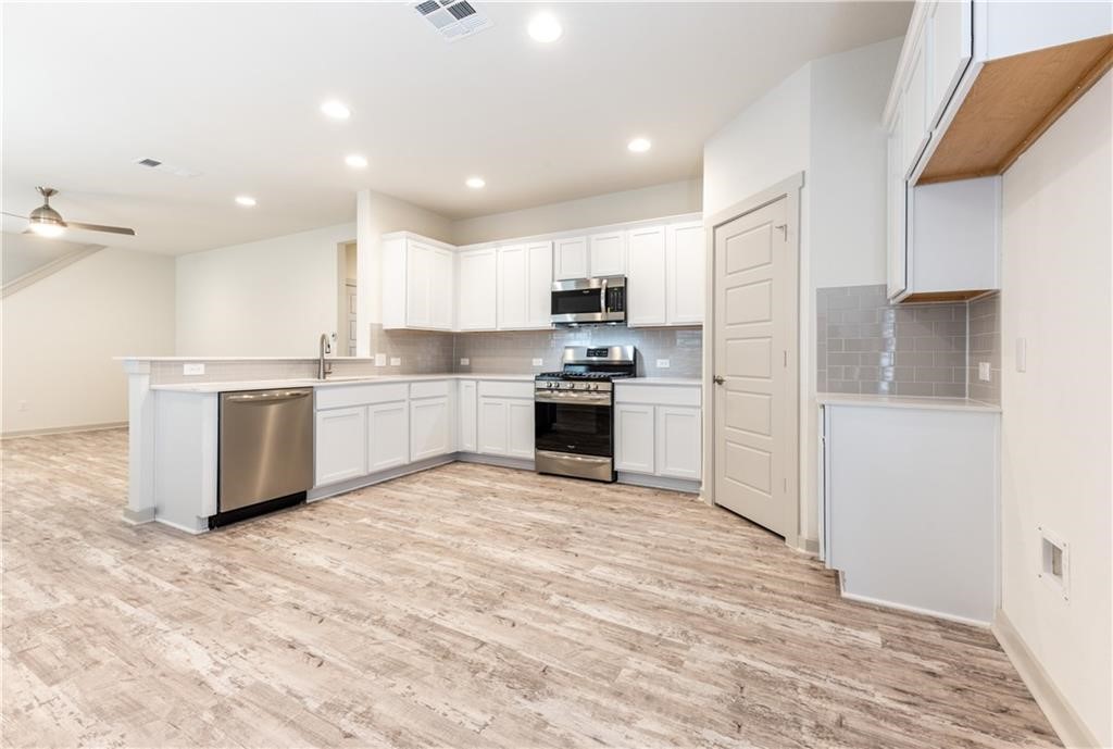 8304 Mimi Lane Austin, TX 78724 - Photo 7 of 32 a kitchen with stainless steel appliances granite countertop a stove top oven a sink and a refrigerator