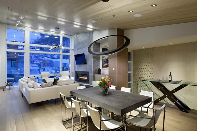 a living room with furniture kitchen view and a chandelier
