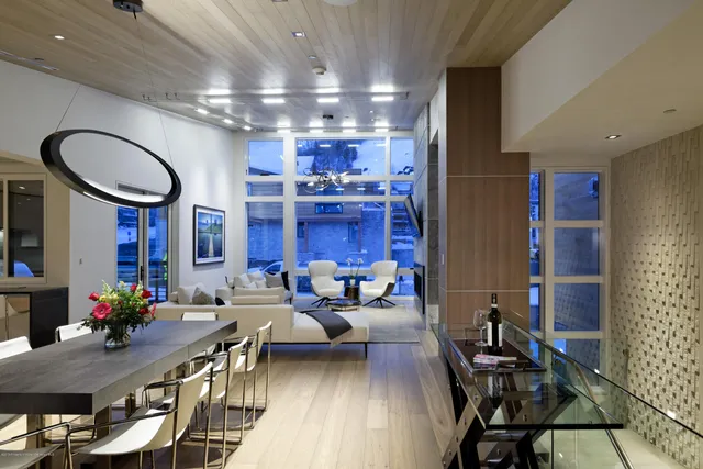 a living room with furniture a large window and a chandelier
