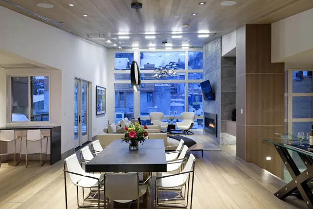 a living room with stainless steel appliances kitchen island a table and chairs in it