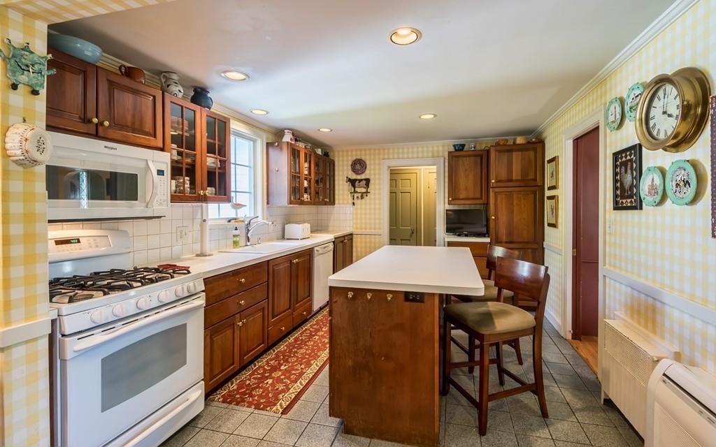 3 Rainbow Road Marblehead, MA 01945 - Photo 12 of 28 a kitchen with stainless steel appliances a stove a sink cabinets and a dining table