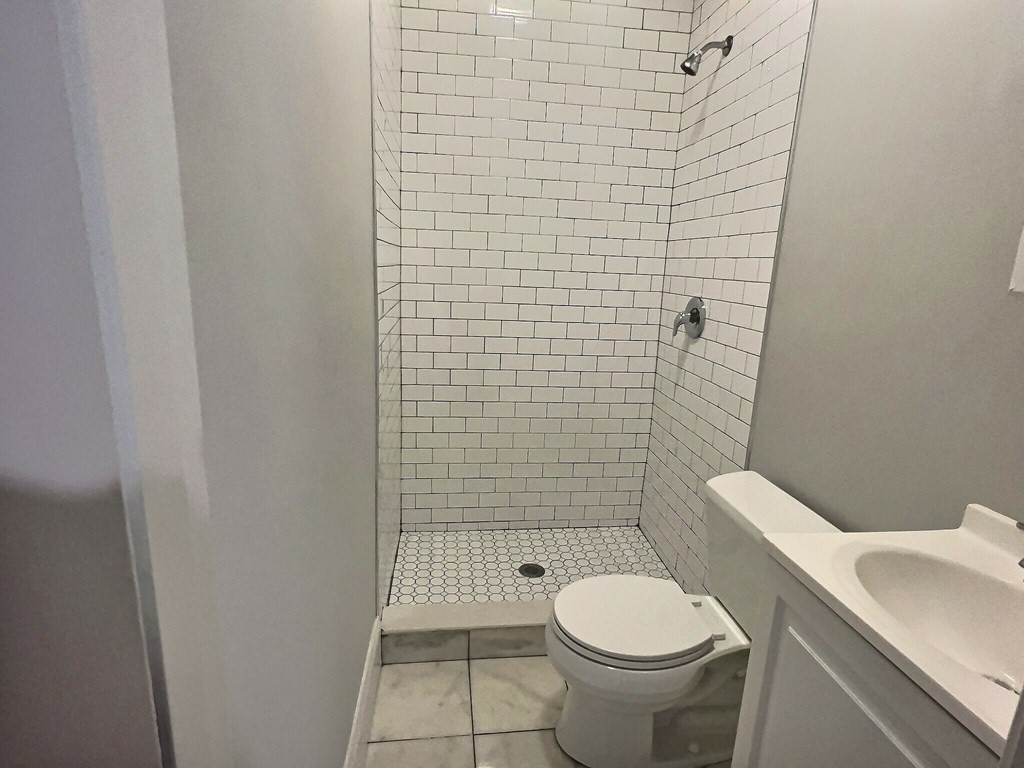 255 Paris Street, Unit 1 Boston, MA 02128 - Photo 13 of 15 a white toilet sitting next to a bathroom sink