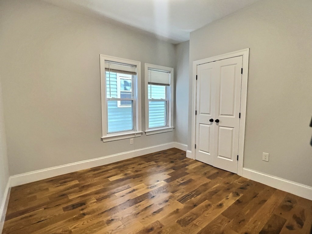 255 Paris Street, Unit 1 Boston, MA 02128 - Photo 10 of 15 a view of an empty room with wooden floor and a window
