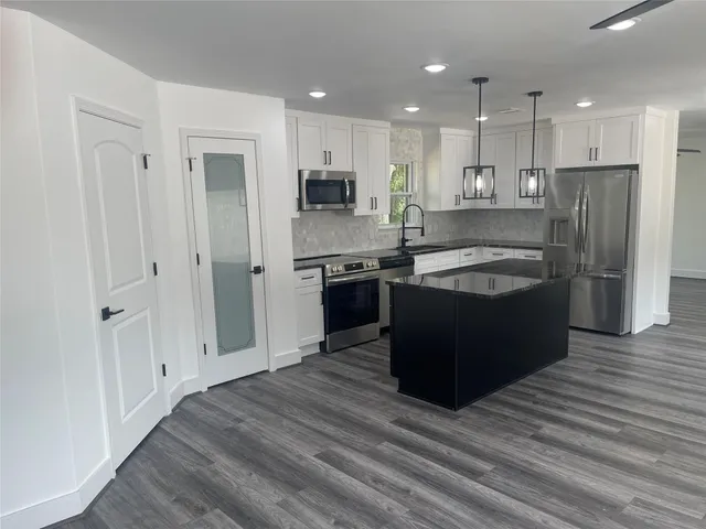 a kitchen with stainless steel appliances granite countertop a stove and a refrigerator