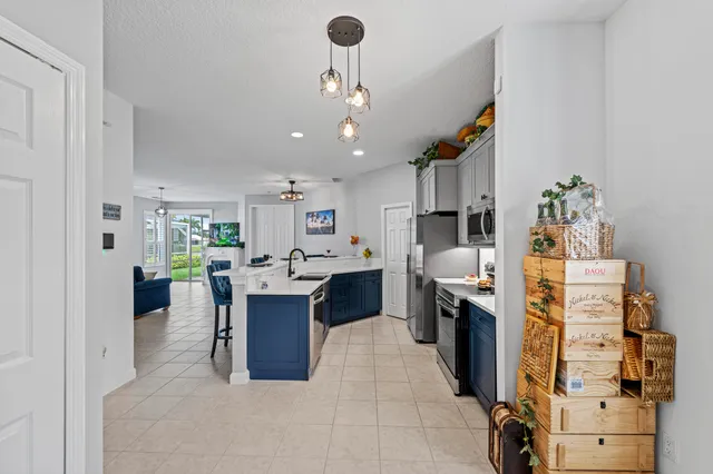a living room with furniture a fireplace kitchen view and a chandelier