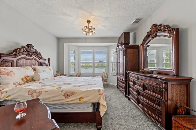 a bedroom with a bed and dresser with mirror