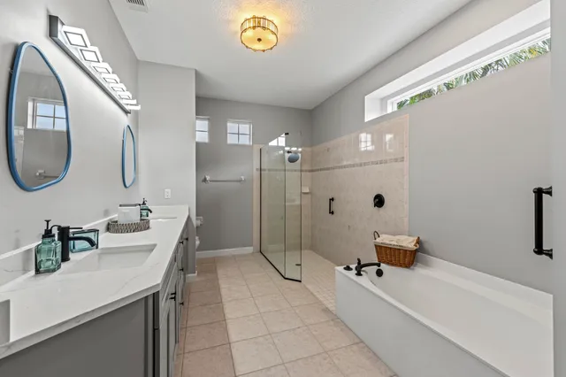 a spacious bathroom with a sink a toilet a mirror and shower