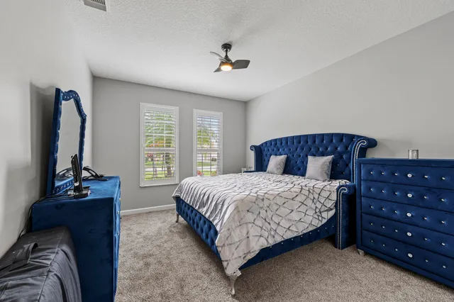 a bedroom with a bed and a flat tv screen on a dresser
