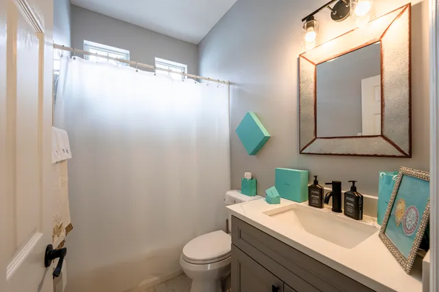 a bathroom with a granite countertop sink mirror vanity and toilet