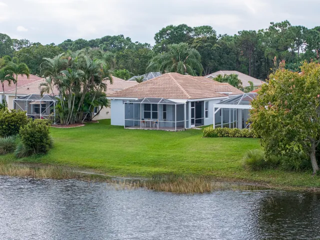 an aerial view of a house with a yard and lake view