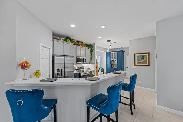 a kitchen with a sink a stove a refrigerator and chairs