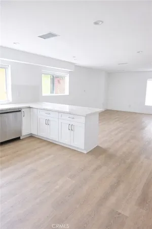 a view of an empty room with window and cabinet