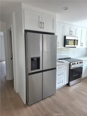 a kitchen with stainless steel appliances a refrigerator sink and stove