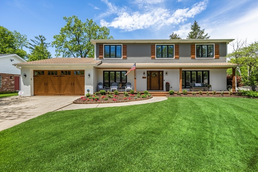 a front view of a house with yard and green space