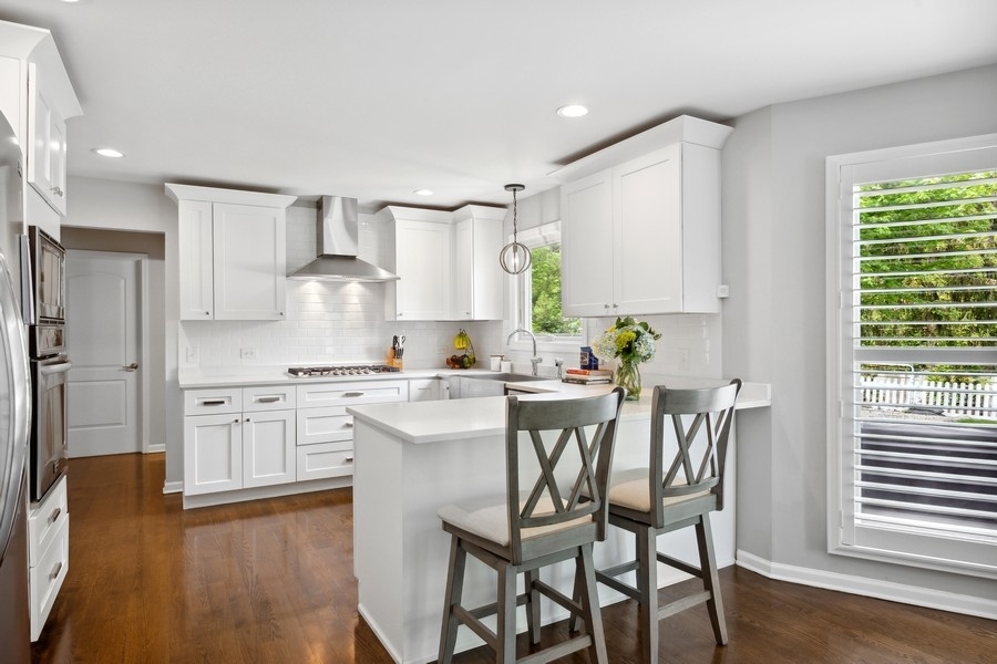3900 Rugen Road Glenview, IL 60025 - Photo 14 of 44 a kitchen with white cabinets and stainless steel appliances