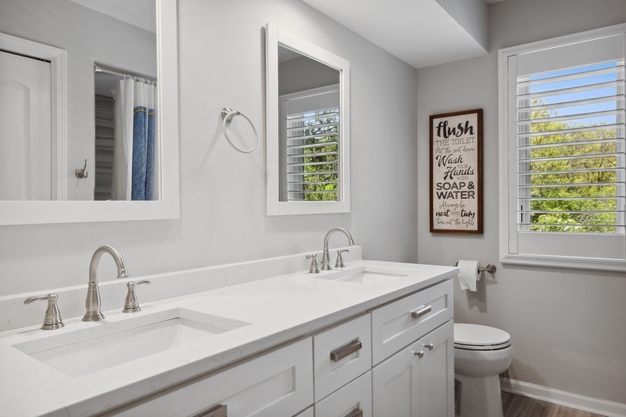 3900 Rugen Road Glenview, IL 60025 - Photo 24 of 44 a bathroom with a double vanity sink toilet and a mirror