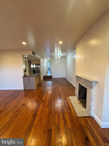 a view of a living room a wooden floor and kitchen