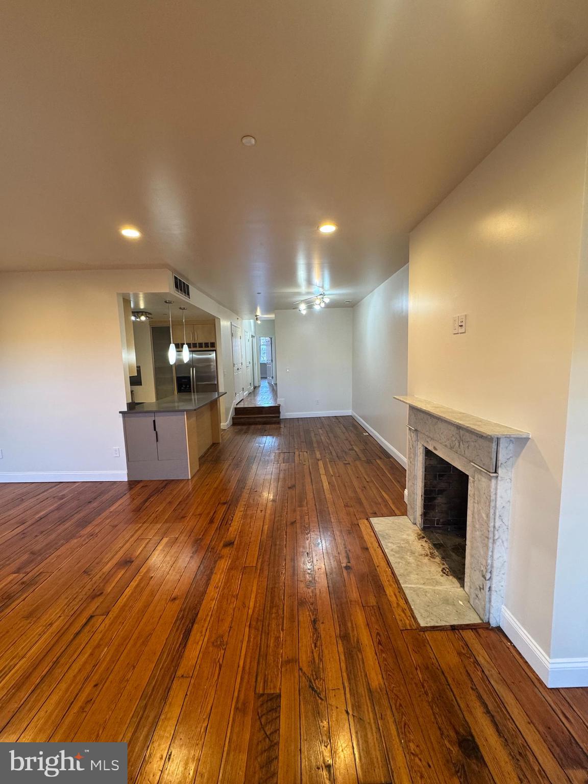 a view of a living room a wooden floor and kitchen