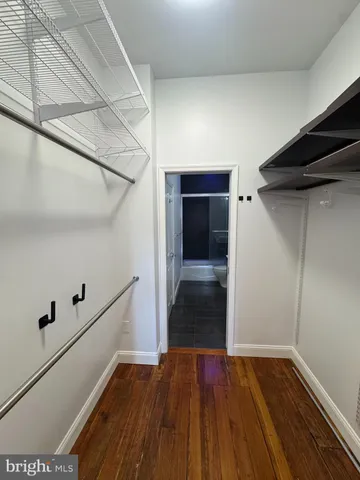 a view of walk in closet with wooden floor