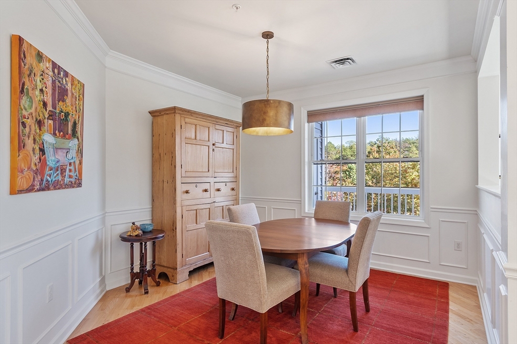 62 Abigail Way, Unit 3004 Reading, MA 01867 - Photo 11 of 37 a dining room with furniture a chandelier and wooden floor