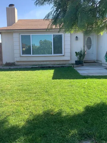 a view of house with backyard space and balcony
