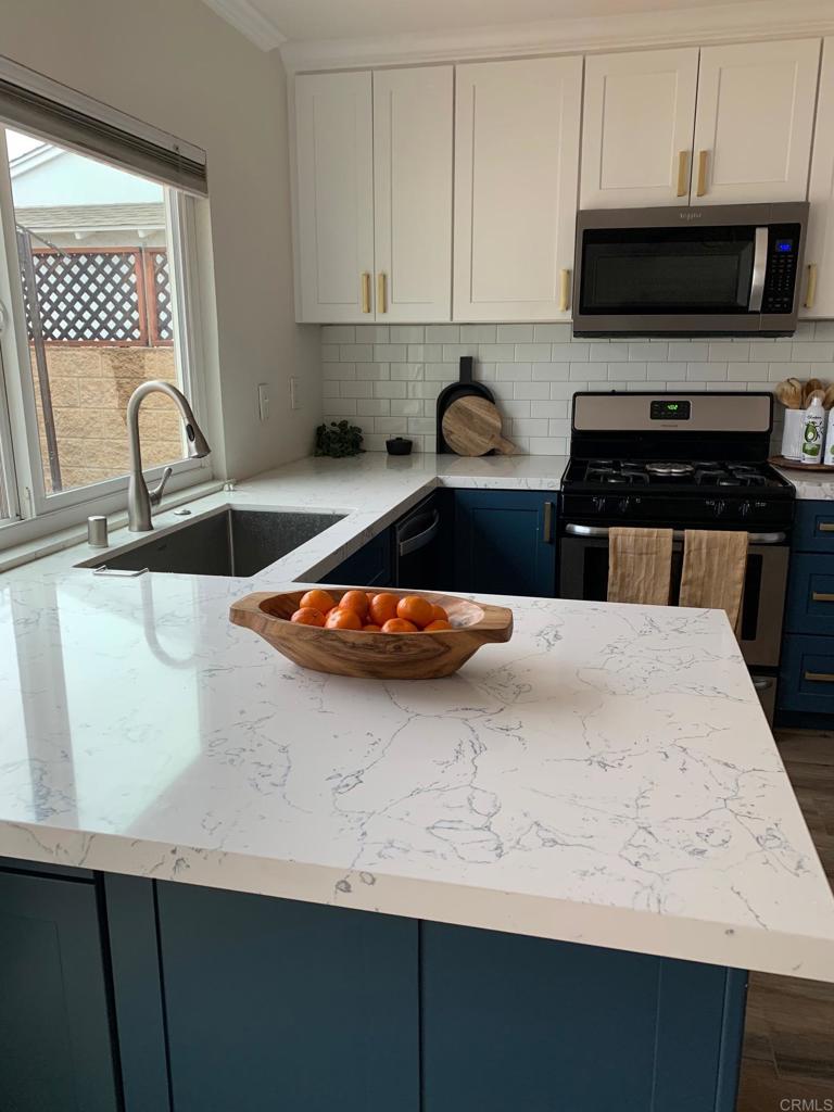 813 Reef Drive San Diego, CA 92154 - Photo 4 of 10 a kitchen with a sink a stove and cabinets