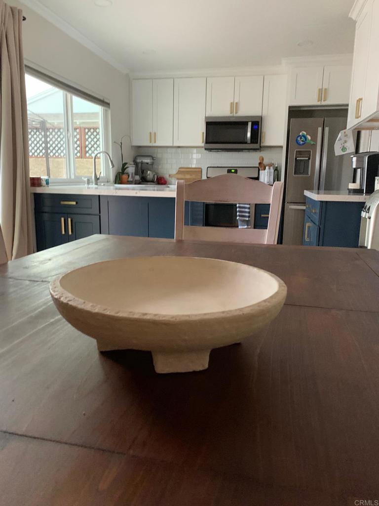 813 Reef Drive San Diego, CA 92154 - Photo 5 of 10 a kitchen with kitchen island a sink table and chairs