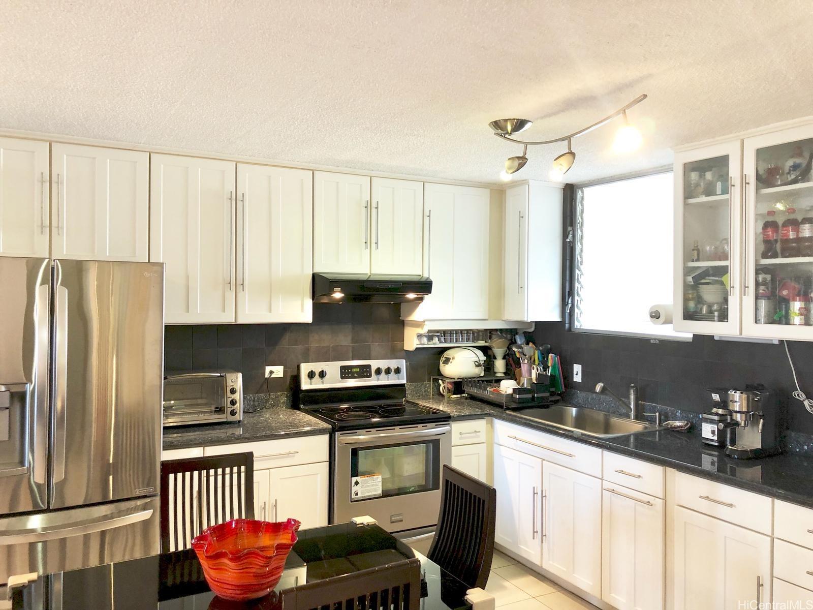 1018 Lunalilo Street, Unit 302 Honolulu, HI 96822 - Photo 1 of 1 a kitchen with stainless steel appliances a sink a stove a refrigerator cabinets and a window