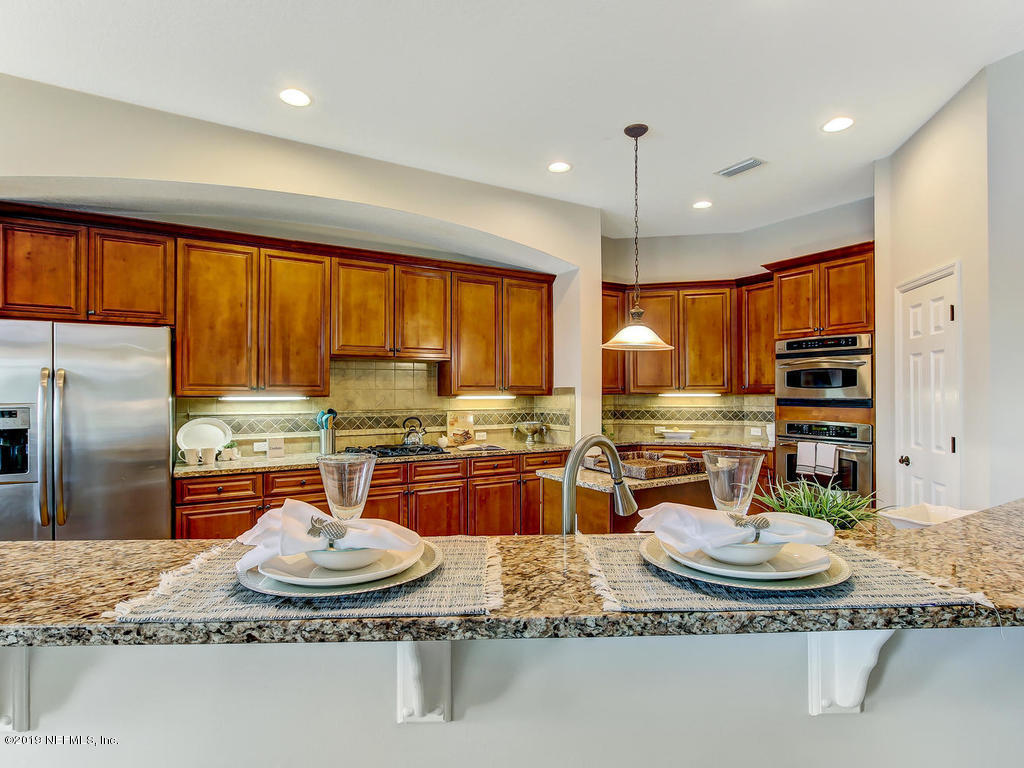 1780 North Loop Parkway St. Augustine, FL 32095 - Photo 23 of 98 a kitchen with granite countertop a stove and refrigerator