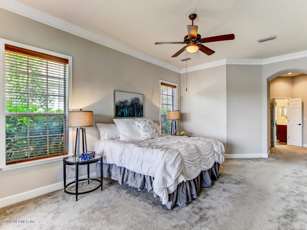 1780 North Loop Parkway St. Augustine, FL 32095 - Photo 33 of 98 a bedroom with a bed and a chandelier